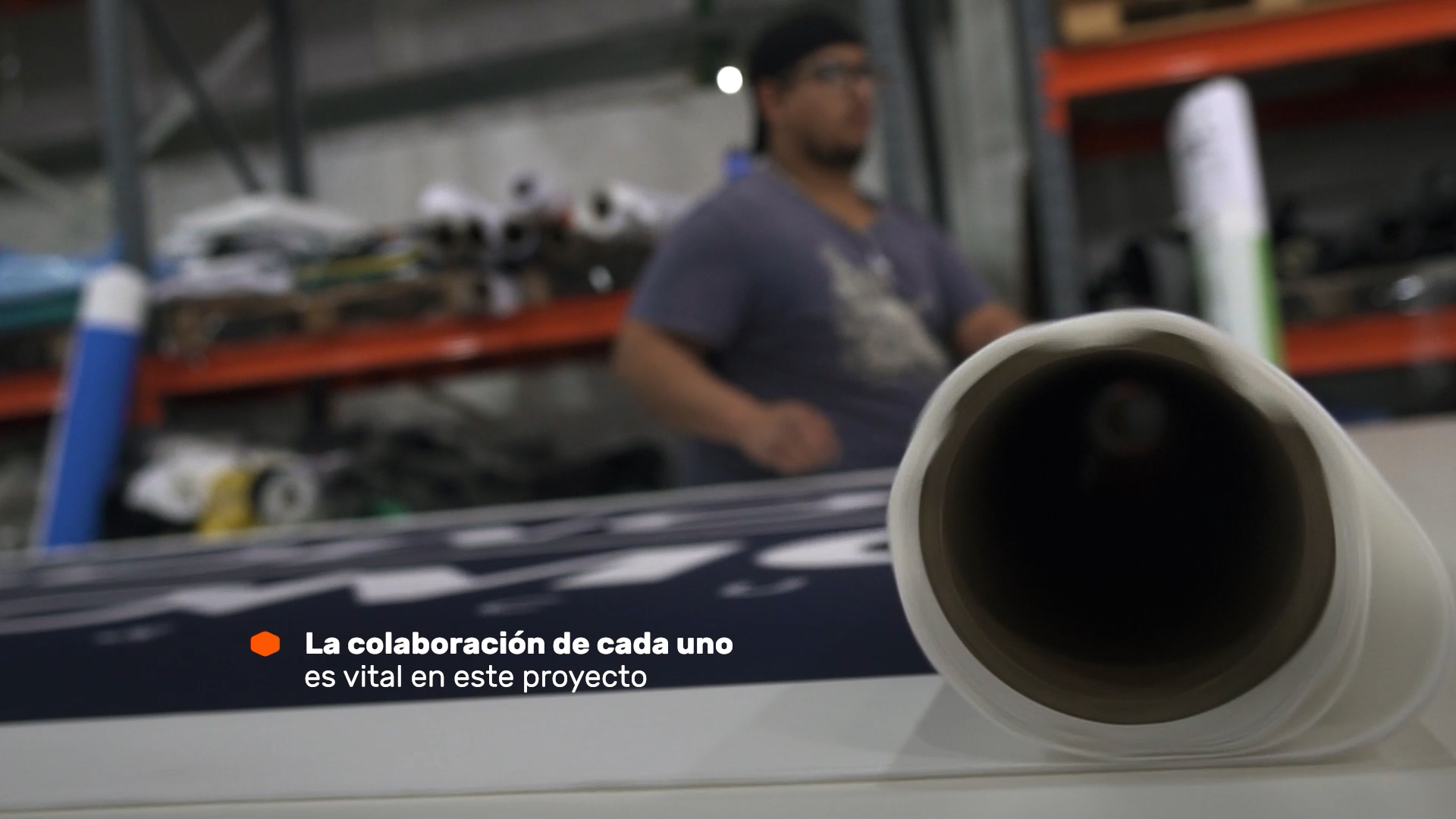 Una persona trabaja con un rollo de material en la fábrica de 3H