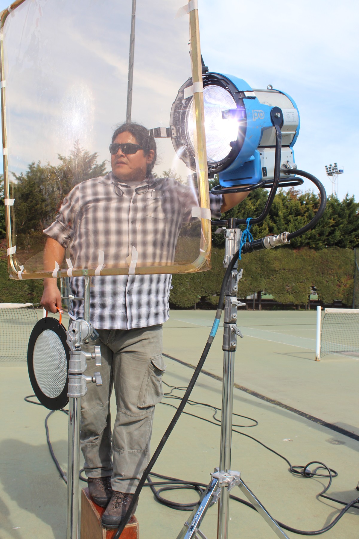 Un integrante del equipo trabaja junto al reflector y el difusor durante el rodaje.