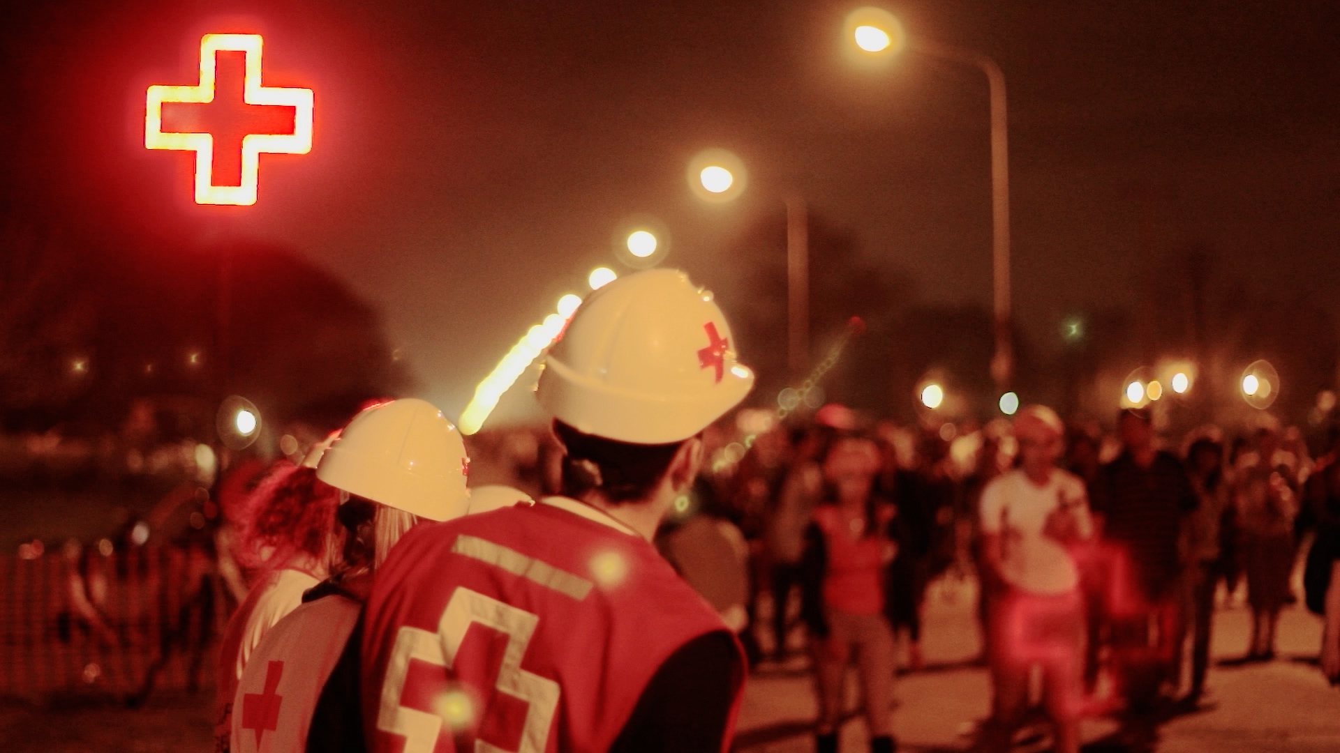 Voluntarios de Cruz Roja reunidos en una escena nocturna